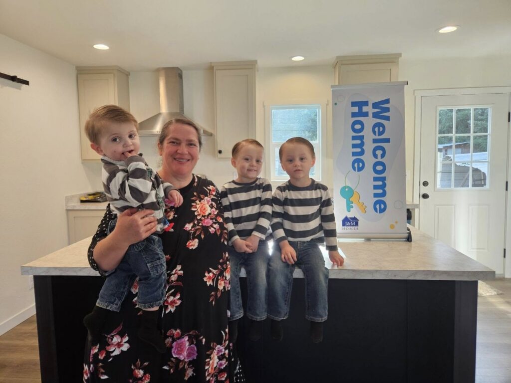mother with three young triplet boys in new mobile home kitchen