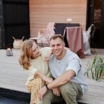 Happy couple sitting and smiling outdoors on a stylish patio.